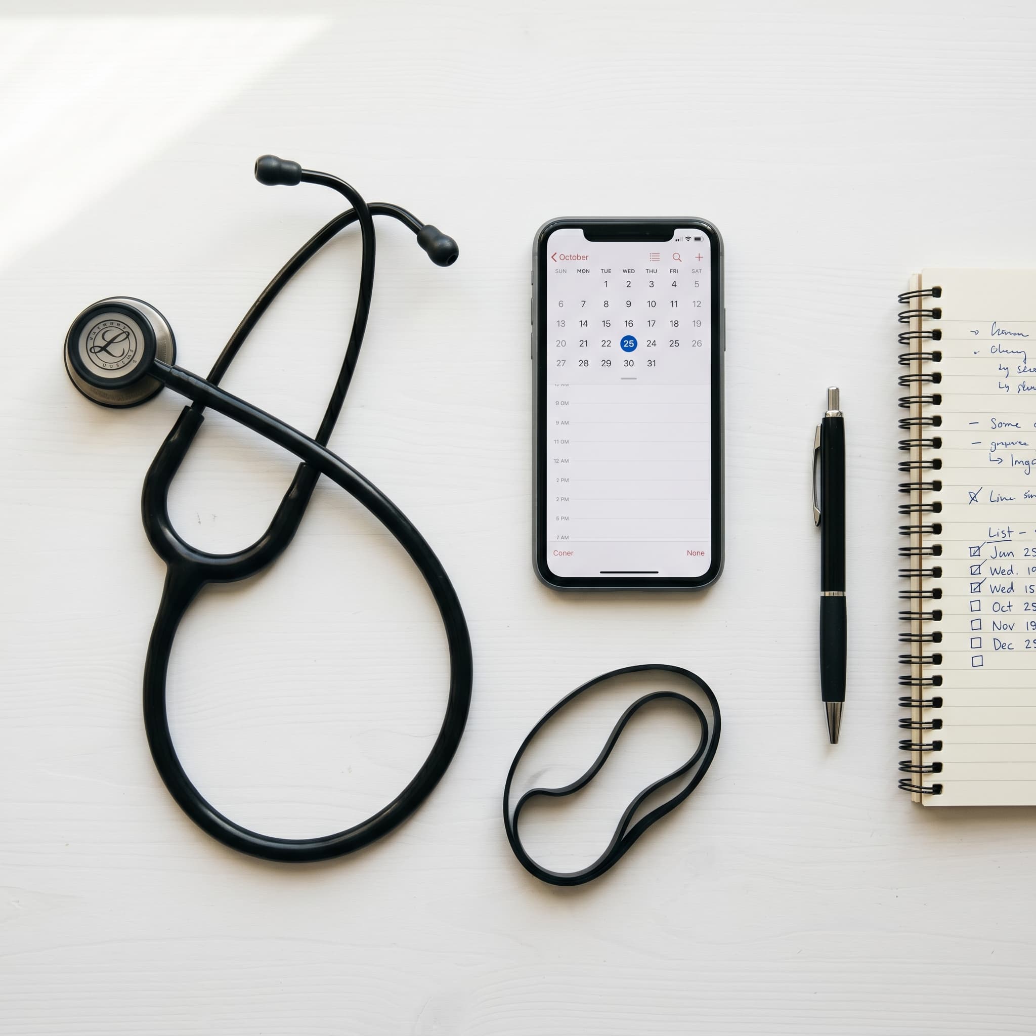 Telefoon met agenda-app, stethoscoop en notitieblok